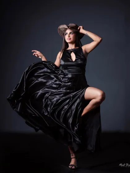 Another angle of the black satin gown, with the model adjusting her hat. This adds a bit of storytelling and personality to the lookbook.
