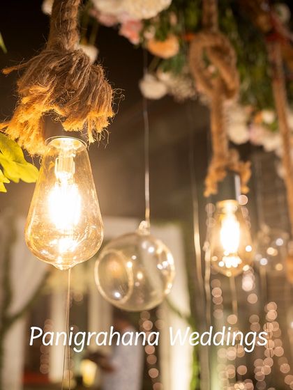 A close-up of hanging Edison bulbs and glass orbs. This combination of rustic and modern lighting elements creates a warm and magical ambiance.