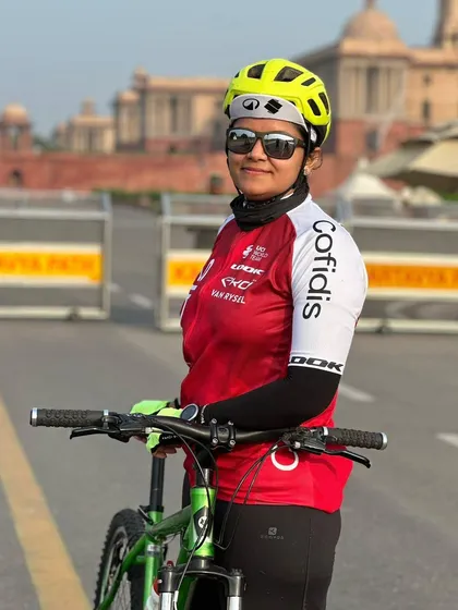 A female cyclist posing with her bike against the backdrop of Rashtrapati Bhavan. Our members are proud to ride through the heart of the nation.