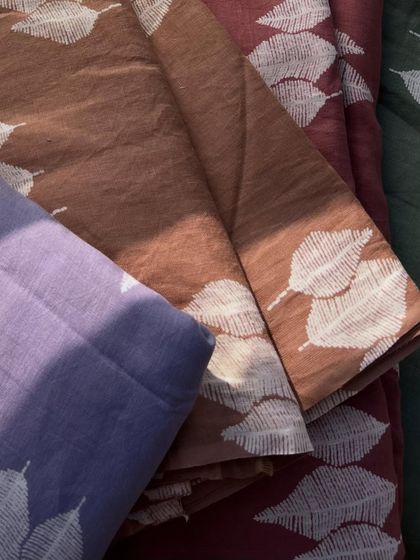 An assortment of our printed pure linen fabrics, showcasing the variety of colors and the beautiful, consistent leaf print.