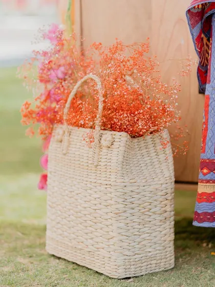 A woven basket filled with orange baby's breath, a simple yet beautiful detail that adds a pop of color and texture.