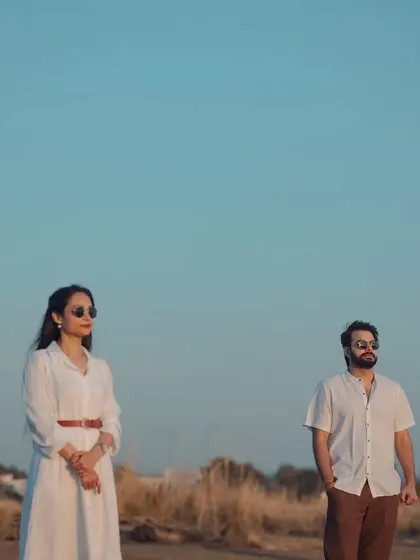 An artistic and minimalist shot in a dry, grassy field. The composition and the couple's pose give this pre-wedding photo a high-fashion, editorial feel.