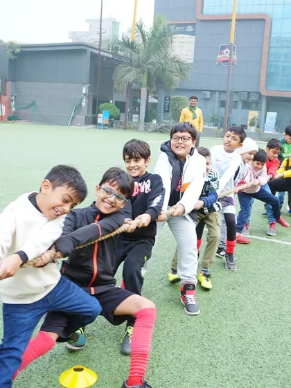 Kids enjoying a game of tug-of-war on the turf, a perfect activity for a high-energy football party.