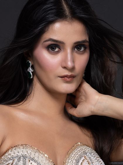 A close-up pageant headshot, capturing the model's warm and engaging expression. The lighting is soft and flattering, perfect for competition portfolios.