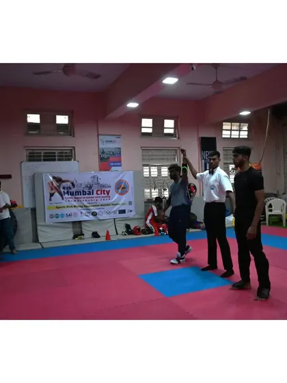 A wide shot of the victory moment, with the referee declaring our athlete the winner. The entire dojo is a witness to his success.