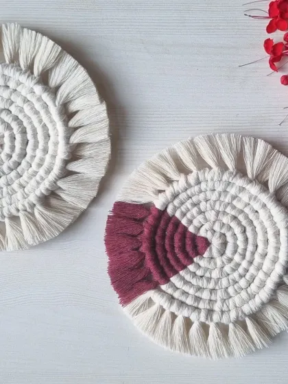 These round coasters feature a striking design with a pop of deep magenta against a natural white. They are a great way to add a touch of boho chic to your home.