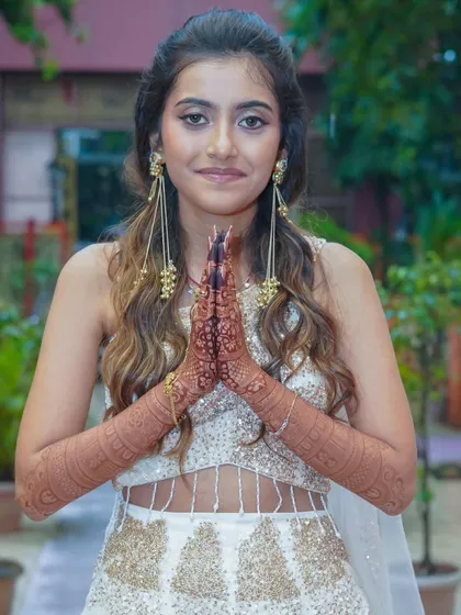 This bride looks absolutely radiant. Her henna stain is a beautiful complement to her elegant white and gold lehenga.