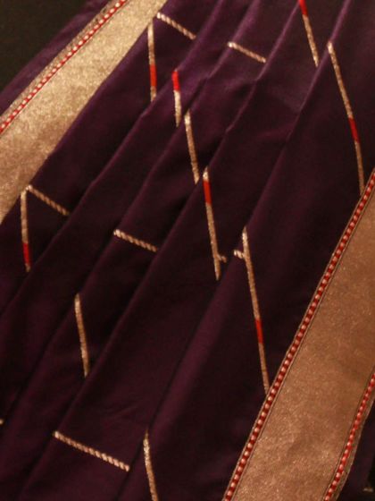 The fine texture and elegant fall of the purple Banarasi Kathan silk saree.