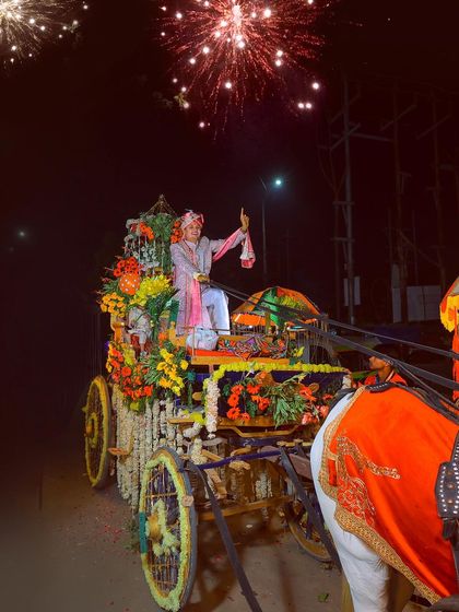 The groom enjoying his Baraat procession with fireworks in the background.