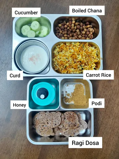 A child's lunchbox is more than just a meal; it's fuel for their day of learning and play. This balanced meal includes carrot rice for energy, boiled chana for protein, ragi dosa for essential nutrients, and fresh cucumber and curd to keep things cool and refreshing.