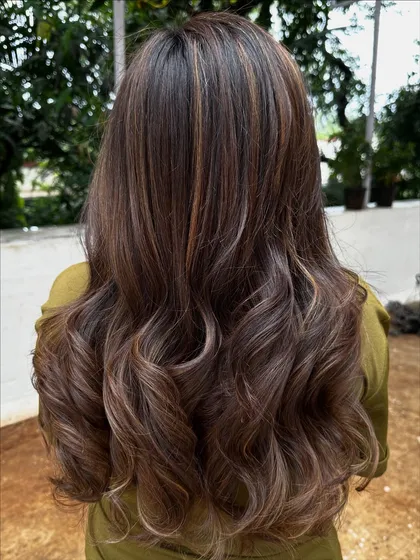 Getting her 'Vacay Hair' on with these beautiful ribbon highlights. This technique creates a gorgeous, flowing look that’s perfect for showing off on your next trip.
