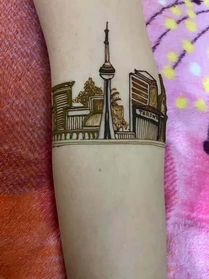 A custom skyline design of the Toronto cityscape, featuring the CN Tower. If a city is part of your story, I can draw its landmark buildings on your arm.