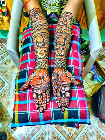 A vibrant, colorful photo of a traditional design with peacocks on the palms and symbolic motifs on the arms.
