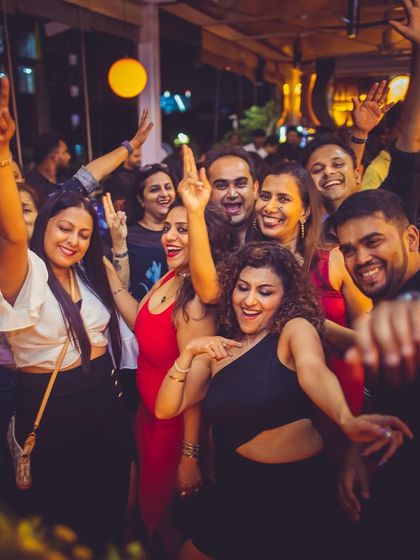 A group of friends dancing and posing for a photo at Badmaash.
