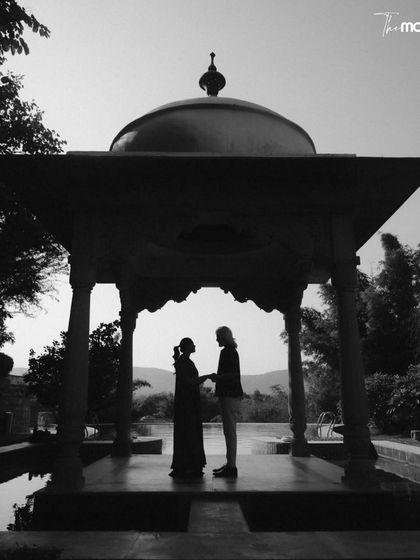 A striking black and white silhouette of the couple under a traditional Rajasthani cenotaph. The strong shapes and contrast create a powerful, artistic image that feels both classic and contemporary.