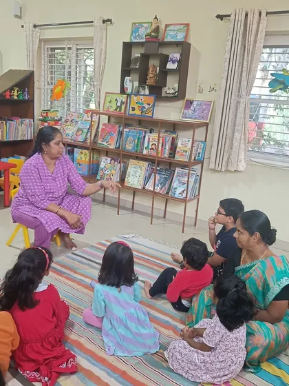 The storyteller points to details in the book, guiding the children's attention and comprehension.