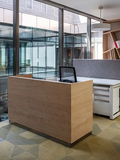 The Arttdi’nox design studio within the Stainless Steel Office. The space is defined by extensive wooden shelving for product display and a large central desk, creating a functional and inspiring environment for the creative team.