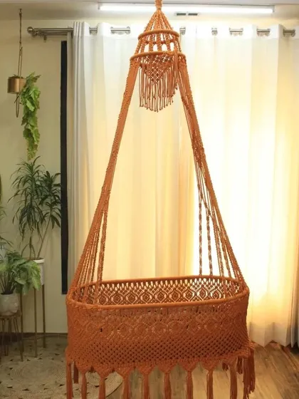 Our macrame baby swing in a warm terracotta color. You can choose any color and design, and we'll make it for you at a price that fits your budget.