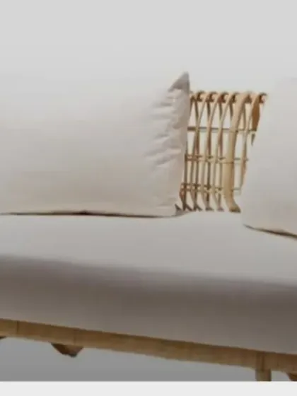 A clean studio view of our two-seater rattan sofa. The open-weave design on the arms and back keeps it feeling light and airy, while the deep seat ensures comfort.