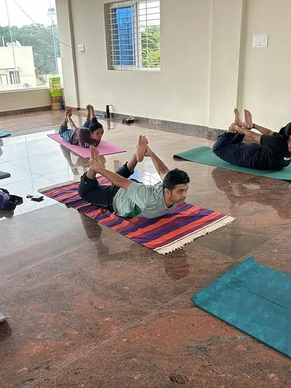 Students practicing Dhanurasana (Bow Pose) together. This pose is fantastic for strengthening the back and improving posture, and it's inspiring to see everyone lift together.