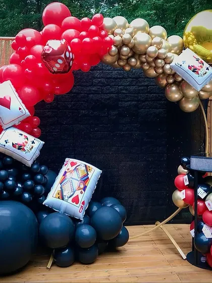 A modern take on a casino theme, with a circular balloon arch in red, black, and gold. I incorporated dice and playing card pillows into the balloon design for a fun, thematic touch.