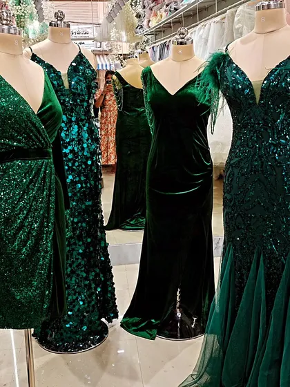A lineup of my emerald green evening gowns, showcasing different textures and styles. From rich velvet to dazzling sequins and feather details, there's a shade of green for every mood.