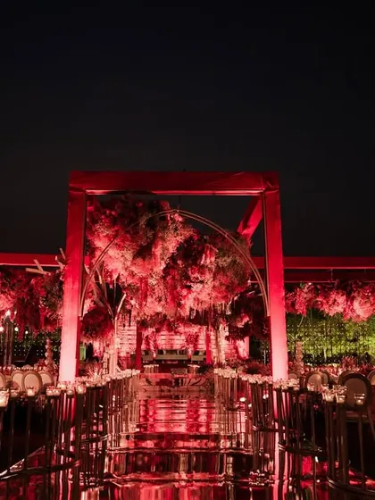 The architectural beauty of the all-red mandap stands out against the night sky. The clean lines of the structure combined with the lush, organic florals created a perfect balance of modern design and timeless romance.
