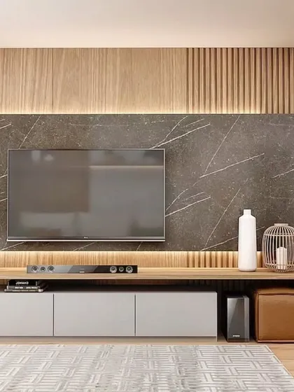 A close-up of the TV unit, featuring a combination of wood paneling, a dark marble backdrop, and a sleek white console.