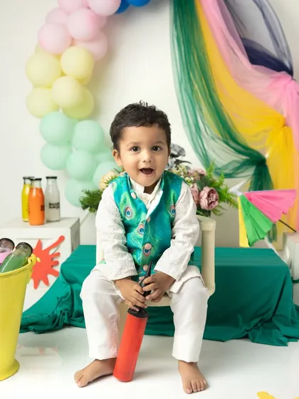 A happy portrait from our Holi mini session, with a rainbow of colors in the background.