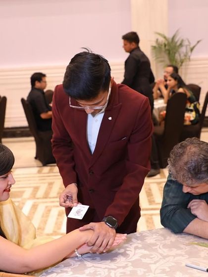 They say magic is the only honest profession because I promise to deceive you, and I do. Here I am performing a close-up trick for guests at their table.