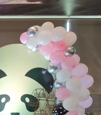 A balloon garland in pink, white, and silver for a panda-themed party.