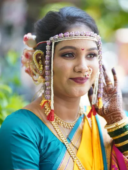 A close-up of a bride's Vidhi look, focusing on her expressive eyes and traditional mundavalya. The makeup is soft yet defined.