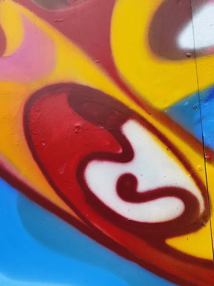 A detail from a vibrant, abstract piece painted in Jakarta. The style is fluid and colorful, like moving water or smoke.