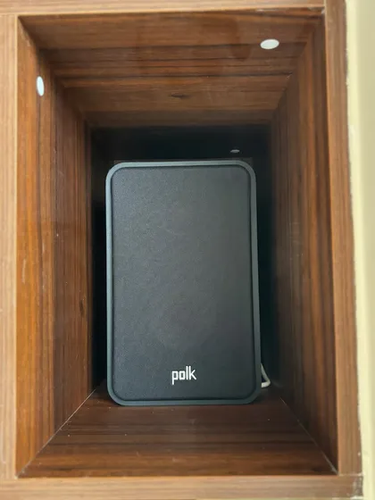 Here's the Polk Audio ES15 bookshelf speaker neatly placed within a custom wooden shelf. Its compact size allows for versatile placement without compromising on sound quality.
