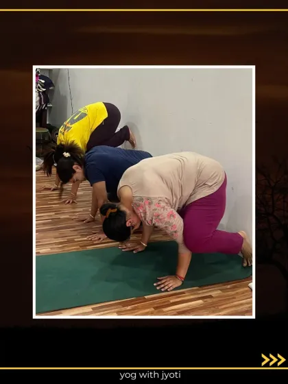 Students practicing the initial stages of Kaagasana (Crow Pose) against a wall for support.