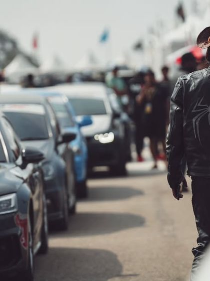 The final call before the race. This image captures the anticipation in the air, with a lineup of cars and the crowd in the background, all ready for the action to begin.
