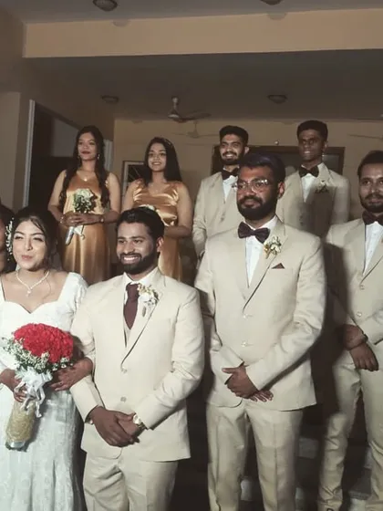 Here’s a look at a fully coordinated wedding party. I created the bride's red rose bouquet and matching artificial flower arrangements for the bridesmaids in gold dresses and boutonnieres for the groom and groomsmen in their beige suits. This ensures a cohesive and picture-perfect look for the entire squad.