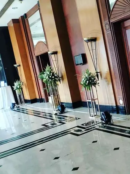 Simple yet effective decor for a hotel corridor. We used tall, minimalist stands with fresh white flower arrangements to line the walkway, adding a touch of class to the space without feeling cluttered.