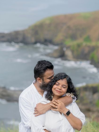 An intimate embrace on a Goan cliffside, with the sea in the background. This shot combines the beauty of the mountains and the ocean.