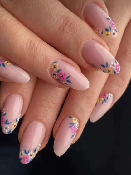 A delicate and pretty design with a nude base and tiny, hand-painted flowers around the cuticle.