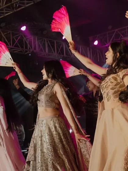 A group of bridesmaids using traditional fans as props in their dance, adding a touch of elegance and visual flair.
