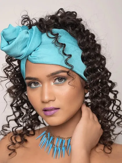 A vibrant, colorful look with a turquoise headwrap and curly hair. This is a great example of playing with color and texture.