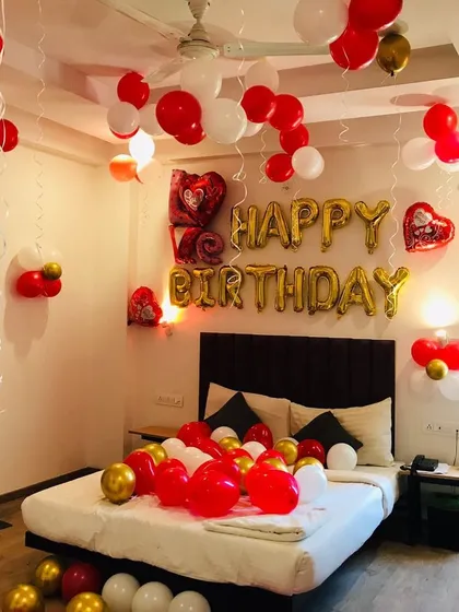 A simple yet beautiful birthday room surprise. We used red, white, and gold balloons on the ceiling and bed, along with foil "Happy Birthday" letters, to create a festive and romantic atmosphere.