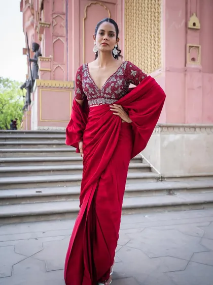 That elegant rich red silk drape saree. Did you know this is pre-stitched and super easy to wear? You can rent this look or buy it from us.
