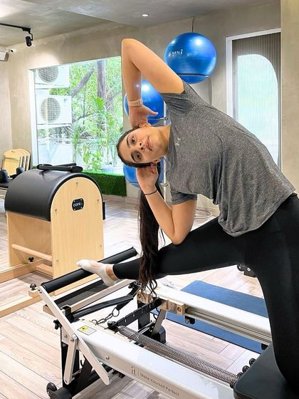 Progress is better than perfection. This mermaid stretch on the Reformer, with the Ladder Barrel in the background, shows the variety of equipment we use.