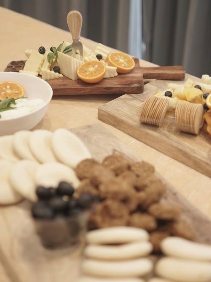 A modern and minimalist presentation of several cheese boards. The arrangement includes a variety of cheeses, crackers, and dips, showcasing a clean and sophisticated approach to gourmet platters.