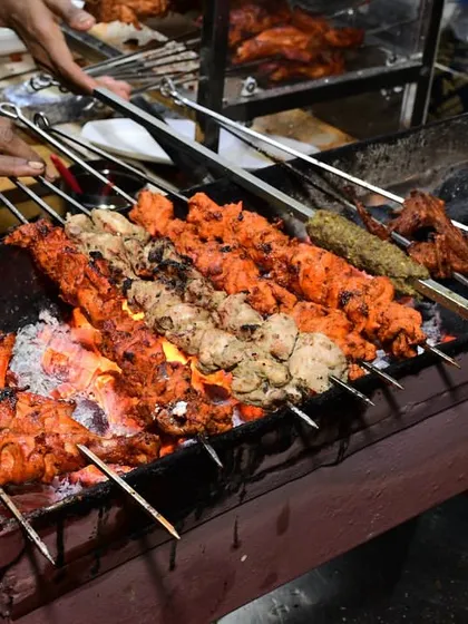 Our barbecue station in full swing, with various chicken tikkas and seekh kebabs grilling over hot coals. The smoky aroma is a big part of the experience at our Ramadan food festival.
