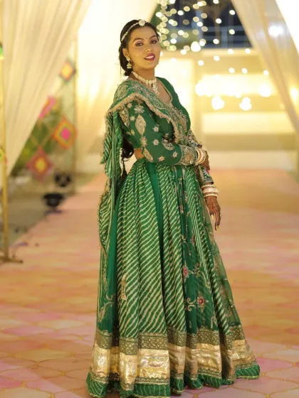 A full-length portrait of the client in her gorgeous green Sangeet outfit.