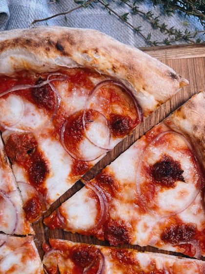 A close-up of a slice of our Goan Sausage pizza. Look at those beautiful rings of onion and spicy sausage.