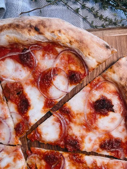A close-up of a slice of our Goan Sausage pizza. Look at those beautiful rings of onion and spicy sausage.